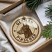 A round ornament with a dog's head and the text "GERMAN PINSCHER" printed on it, hanging from a string.