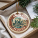 A circular ornament with a picture of a city skyline and the text "Ghent, Belgium" is displayed in a box with pine branches.