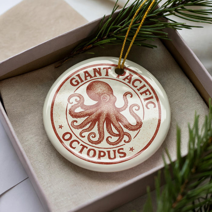 A round ornament with an image of an octopus and the text "GIANT PACIFIC OCTOPUS" is displayed in a box, surrounded by pine branches.