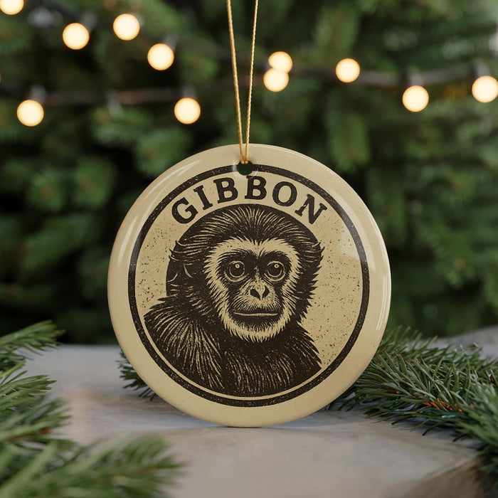 A round ornament with a monkey's face on it, hanging from a string.