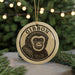 A round ornament with a monkey's face on it, hanging from a string.