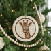 A Christmas tree decorated with ornaments, including a circular ornament featuring a giraffe's face.