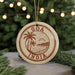 A circular ornament with the text "GOA INDIA" and a palm tree illustration, hanging in front of a Christmas tree with twinkling lights.