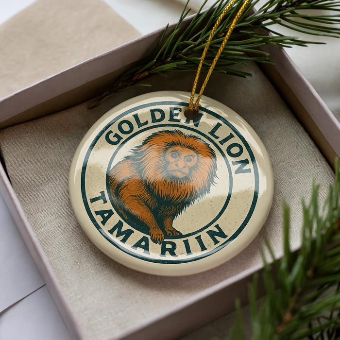 A decorative ornament featuring a golden lion, a symbol associated with the Tamarin monkey, is displayed in a box surrounded by pine branches.