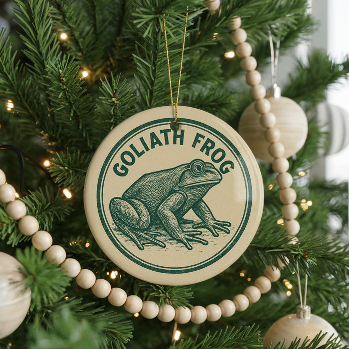 A Christmas tree decorated with ornaments, including a circular ornament with a frog image and the text "GOLIATH FROG" on it.