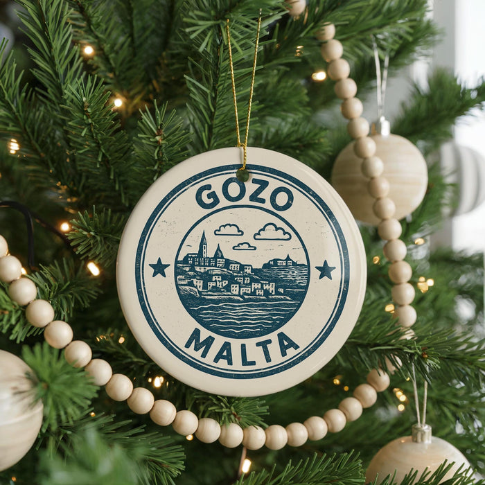 A Christmas tree decorated with ornaments, including a circular ornament with the text "GOZO MALTA" and a small wooden bead decoration.