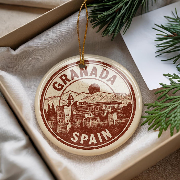 A circular ornament with the text "GRANADA SPAIN" printed on it, hanging from a string.