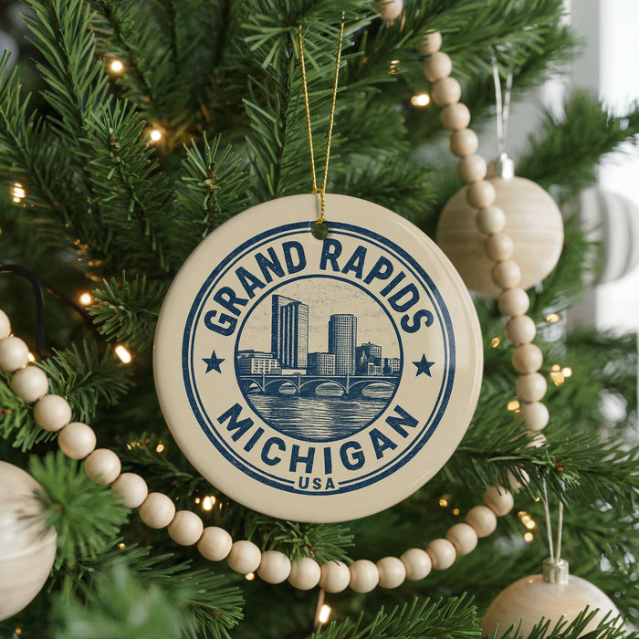 A circular ornament on a Christmas tree, featuring the text "GRAND RAPIDS MICHIGAN USA" and an illustration of a city skyline.