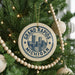 A circular ornament on a Christmas tree, featuring the text "GRAND RAPIDS MICHIGAN USA" and an illustration of a city skyline.