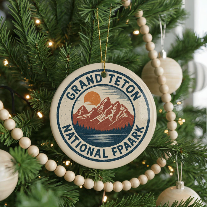 A Christmas tree decorated with ornaments, including a circular ornament with the text "GRAND Teton NATIONAL FPAARK" and a mountain landscape design.