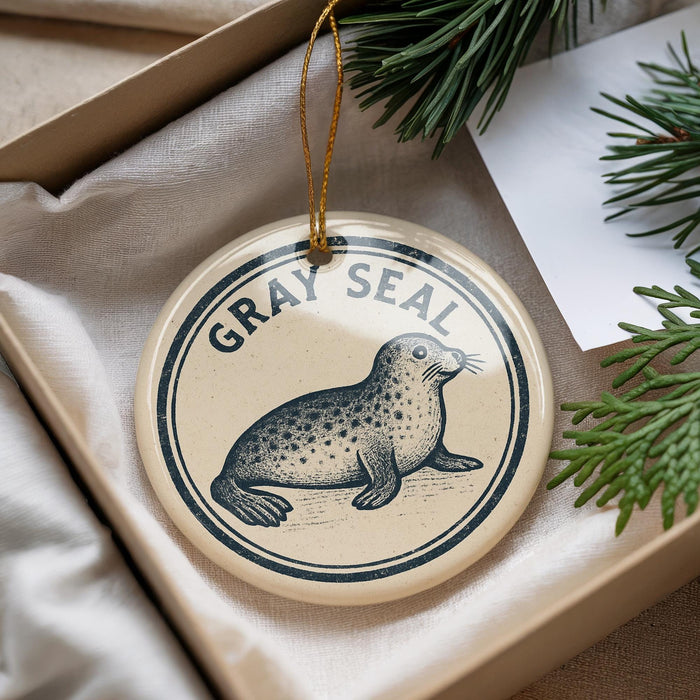 A circular ornament with a seal image and the text "GRAY SEAL" is displayed in a box, surrounded by pine branches.