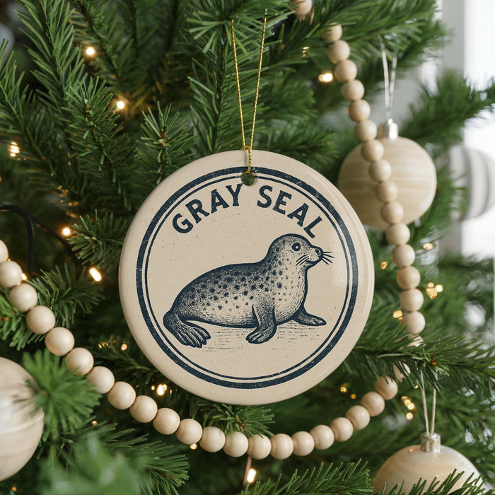 A Christmas tree decorated with ornaments, including a circular ornament with a seal design and the text "GRAY SEAL" on it.