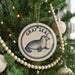 A Christmas tree decorated with ornaments, including a circular ornament with a seal design and the text "GRAY SEAL" on it.