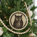 A Christmas tree decorated with ornaments, including a circular ornament featuring an image of an owl.