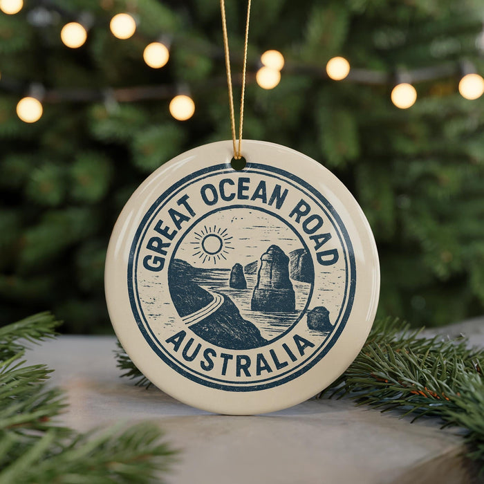 A circular ornament with the text "GREAT OCEAN ROAD AUSTRALIA" printed on it, surrounded by pine branches and lights.