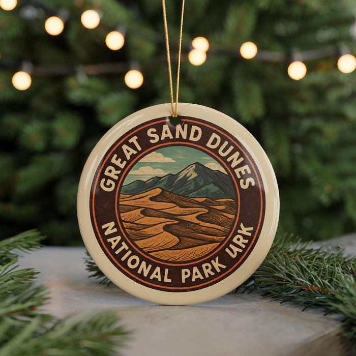A circular ornament with the text "GREAT SAND DUNES NATIONAL PARK URK" and an illustration of a desert landscape with mountains in the background.