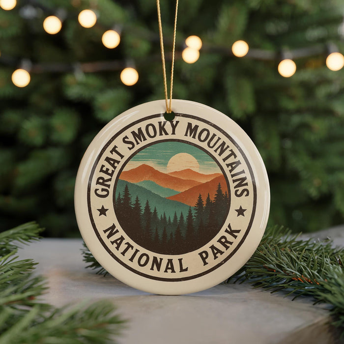 A circular ornament with the text "GREAT SMOKY MOUNTAINS NATIONAL PARK" and a mountain landscape design, hanging from a string.