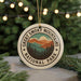 A circular ornament with the text "GREAT SMOKY MOUNTAINS NATIONAL PARK" and a mountain landscape design, hanging from a string.