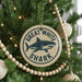 A Christmas tree decorated with ornaments, including a large circular ornament with a shark image and the text "GREAT WHITE SHARK" on it.