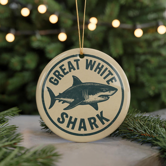 A circular ornament with the text "GREAT WHITE SHARK" and a graphic of a shark is displayed in front of a Christmas tree with twinkling lights.