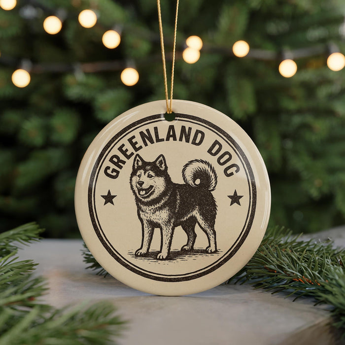 A circular ornament featuring a black and white illustration of a husky dog, with the text "GREENLAND DOG" around the edge.