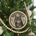 A Christmas tree decorated with ornaments, including a circular ornament featuring a wolf's face and the text "GREY WOLF".