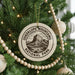 A Christmas tree decorated with ornaments, including a circular ornament with the text "GUADALUPE MOUNTAINS NATIONAL PARK" and a mountain illustration.