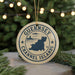 A circular ornament with the text "GUERNSEY CHANNEL ISLANDS" and a graphic of a map of the Channel Islands, hanging from a string.
