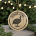 A round ornament with the text "GUINEA FOWL" and an illustration of a guinea fowl is displayed on a Christmas tree.
