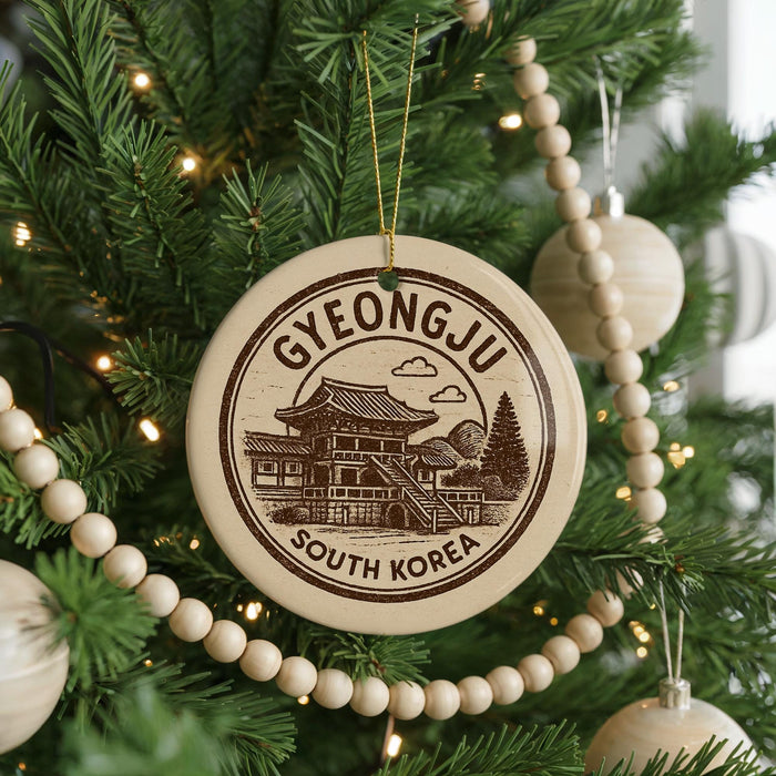 A Christmas tree decorated with ornaments, including a circular ornament with a picture of a temple and the text "GYEONGJU SOUTH KOREA".