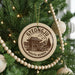 A Christmas tree decorated with ornaments, including a circular ornament with a picture of a temple and the text "GYEONGJU SOUTH KOREA".
