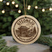 A circular ornament with a design depicting a traditional Korean temple, surrounded by Christmas lights and greenery.