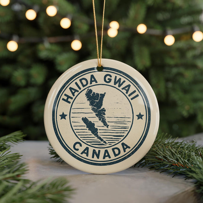 A circular ornament with the text "HAIDA GWALL CANADA" printed on it, hanging from a string.