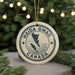 A circular ornament with the text "HAIDA GWALL CANADA" printed on it, hanging from a string.
