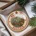 A circular ornament with the text "HALLSTATT AUSTRIA" and an illustration of a town, surrounded by greenery.