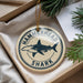 A round ornament with a hammerhead shark design and the text "HAMMERHEAD SHARK" is displayed in a box with pine branches.