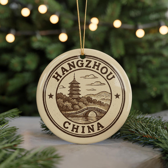 A circular ornament with the text "HANGHOU CHINA" and an illustration of a pagoda, bridge, and mountains, hanging from a string.
