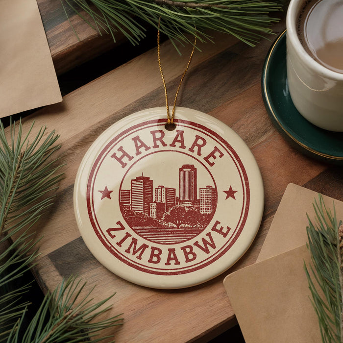 A circular ornament with the text "HARARE ZIMBABWE" printed on it, surrounded by pine branches and a cup of coffee on a wooden surface.