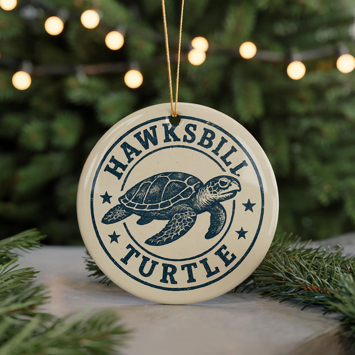 A circular ornament with a turtle design, featuring the text "HAWKSBILL TURTLE" in a blue and white color scheme.