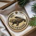 A circular ornament with a salamander design, hanging from a string.
