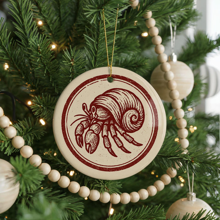 A Christmas tree decorated with ornaments, including a circular ornament featuring a red and white crab design.