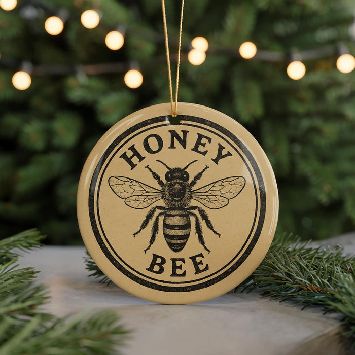 A round ornament with the text "HONEY BEE" and a bee illustration, hanging from a string.