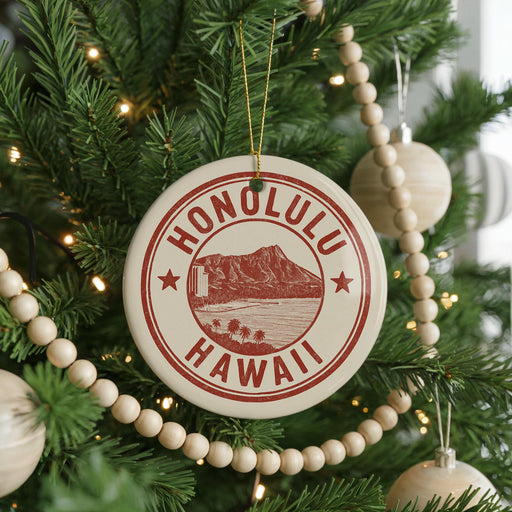A circular ornament on a Christmas tree with the text "HAWAII" in red and white, featuring a mountain and beach scene.