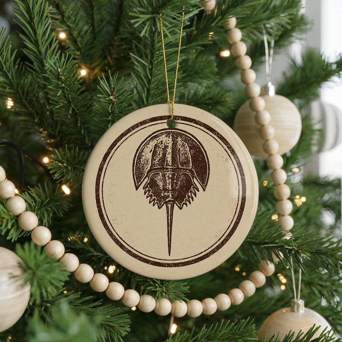 A Christmas tree decorated with ornaments, including a circular ornament with a graphic of a horseshoe.