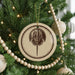 A Christmas tree decorated with ornaments, including a circular ornament with a graphic of a horseshoe.