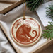 A round ornament with a monkey image and the text "HOWLER MONKEY" is displayed in a box with pine branches.