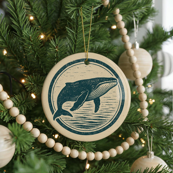 A Christmas tree decorated with ornaments, including a circular ornament featuring a whale design.