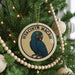 A round ornament on a Christmas tree featuring a blue parrot.
