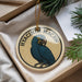 A round ornament featuring a blue parrot, with the text "HVACINTH MACAW" written around the edge.