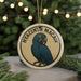 A round ornament featuring a blue parrot, with the text "HYACINTH MACAW" written around the bird's image.